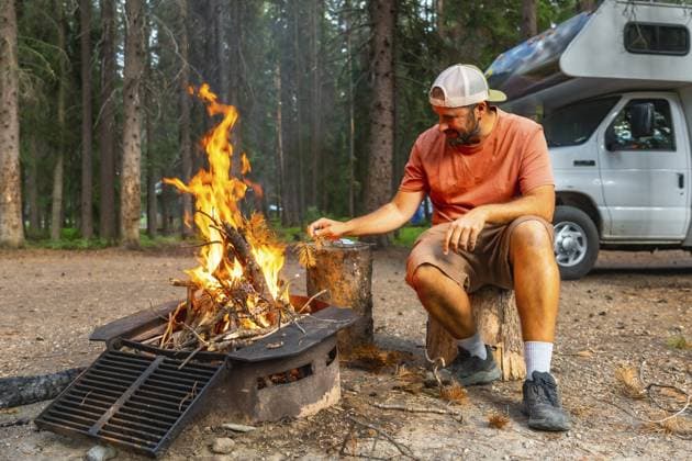 Tourist, der Lagerfeuerflammen in der Nähe eines Wohnmobils im Banff Nationalpark, Kanadische Rocky Mountains, Alberta, füttert und ein friedliches Campingerlebnis inmitten der Natur genießt Tourist feeding campfire flames near camper van in banff national park, canadian rockies, alberta, enjoying peaceful camping experience surrounded by nature Copyright: imageBROKER UnaixHuizi ibluhu16055826.jpg ,model released, Symbolfoto ,property released