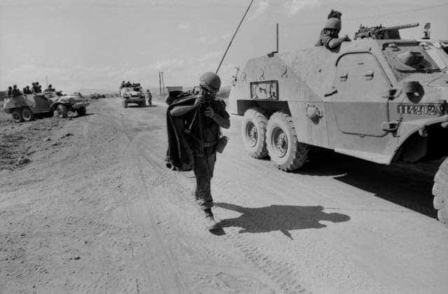 Ein israelischer Soldat mit Funkantenne und Ausrüstung läuft neben einem gepanzerten Spähfahrzeug über eine staubige Piste. Szene aus dem Jom-Kippur-Krieg, Oktober 1973. Israel Syrien *** a Israeli Soldier with Radio antenna and Equipment running next to a armoured Spähfahrzeug via a dusty Runway Scene from the Jom KIPPUR War, October 1973 Israel Syria Copyright: xUnitedxArchivesx xSvenxSimonxArchives SVS_94010002343