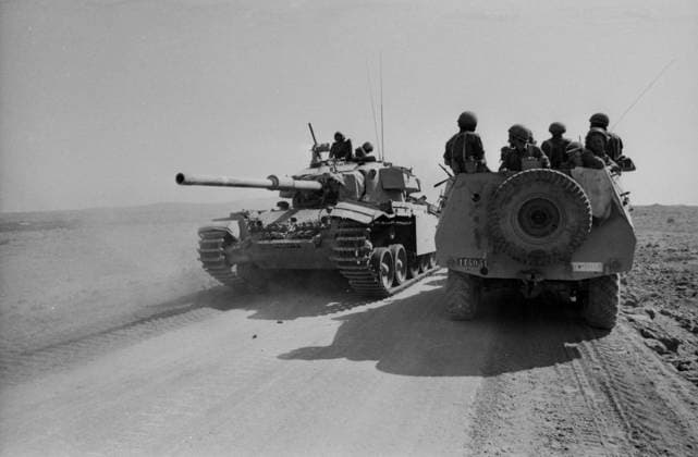 Ein israelischer Kampfpanzer passiert auf einer staubigen Piste einen mit Soldaten besetzten Spähwagen. Szene aus dem Jom-Kippur-Krieg 1973 auf einem Militärkorridor in der Wüste Sinai. Israel Syrien *** a Israeli Battle tanks happens at a dusty Runway a with Soldiers occupied Spähwagen Scene from the Jom KIPPUR War 1973 at a Military corridor in the Desert Sinai Israel Syria Copyright: xUnitedxArchivesx xSvenxSimonxArchives SVS_94010002344