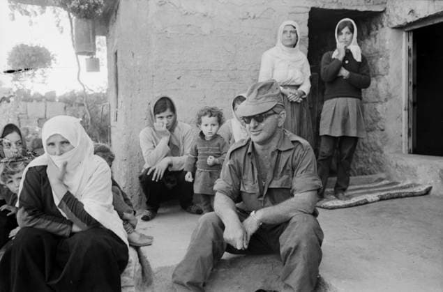 Ein israelischer Offizier sitzt mit Sonnenbrille und Uniform entspannt auf der Türschwelle eines Hauses in einem syrischen Dorf während des Jom-Kippur-Krieges 1973. Um ihn herum stehen und sitzen syrische Frauen und Kinder, teils neugierig, teils zurückhaltend. Golan-Höhen Syrien *** a Israeli Officer sits with Sunglasses and Uniform relaxed at the Threshold one House in a Syrian Village during of Jom KIPPUR War 1973 at him around Standing and sit Syrian Women and Children, partly curious, partly restrained Golan Heights Syria Copyright: xUnitedxArchivesx xSvenxSimonxArchives SVS_94010002375