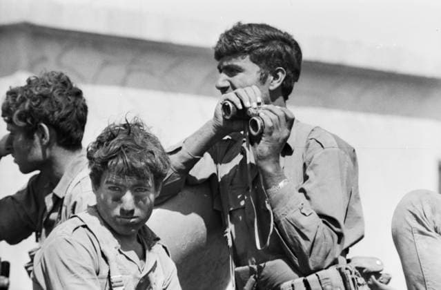 Israelische Soldaten während eines Einsatzes im Jom-Kippur-Krieg 1973 - einer blickt durch ein Fernglas, der andere erschöpft im Vordergrund mit verschmutztem Gesicht. Golan-Höhen Syrien *** Israeli Soldiers during one Deployment at Jom KIPPUR War 1973 a looks through a Binoculars, the other exhausted at Foreground with polluted Face Golan Heights Syria Copyright: xUnitedxArchivesx xSvenxSimonxArchives SVS_94010002389