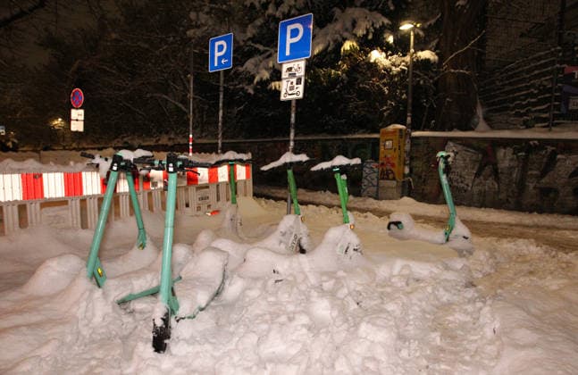 Mit Schnee bedeckte E-Scooter stehen während des Sturmtiefs Elli auf einem extra für sie reservierten Parkplatz in der Schanzenstraße. Sternschanze Hamburg