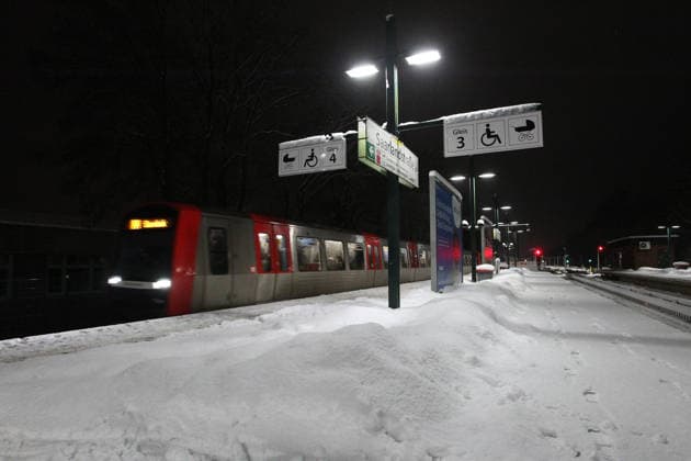 Eine U-Bahn der Linie U3 fährt in die Haltestelle Saarlandstraße hinein. Der Bahnsteig ist während des Sturmtiefs Elli mit Schnee überdeckt. Barmbek Hamburg