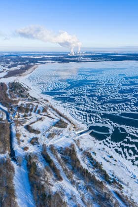 Winterwetter in Brandenburg DEU Deutschland Brandenburg Cottbus, 10.01.2026, Winter am Cottbuser Ostsee, Kraeftige Schneefaelle des Winter-Sturmtiefs Elli haben die Lausitz und die Stadt Cottbus mit dem Cottbuser Ostsee in eine eisige, verschneite Winterlandschaft verwandelt. Blick ueber den teilweise zugefrorenen Cottbuser Ostsee. Am Horizont das Braunkohlekraftwerk Jaenschwalde. Luftaufnahme mit einer Drohne. *** Winter weather in Brandenburg DEU Germany Brandenburg Cottbus, 10 01 2026, Winter at Cottbuser Ostsee, Heavy snowfalls from winter storm Elli have transformed Lusatia and the city of Cottbus with Cottbuser Ostsee into an icy, snowy winter landscape View over the partially frozen Cottbuser Ostsee On the horizon the lignite-fired p AF_Cottbus_Ostsee_31991