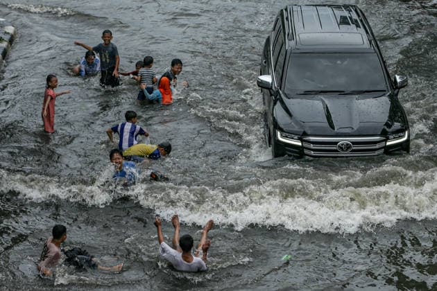 January 12, 2026, Jakarta, Java, Indonesia: Children play on a flooded street in Jakarta, Indonesia. The Jakarta Regional Disaster Management Agency (BPBD) noted that 23 roads and 10 subdistricts in South Jakarta and North Jakarta were flooded due to heavy rain and poor drainage systems in the area. Jakarta Indonesia - ZUMAp283 20260112_zip_p283_039 Copyright: xClaudioxPramanax