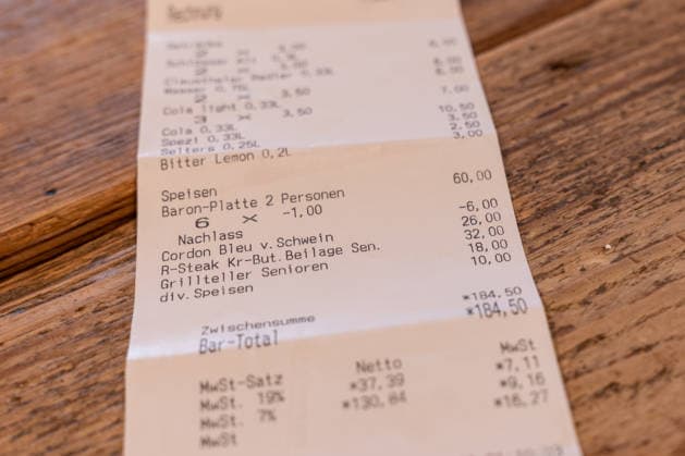 Kassenbon zeigt Mehrwertsteuer von 7 und 19 Prozent in der Gastronomie 13.01.26, Selters: Symbolfoto, Illustrationsbild, Symbolbild, Illustrationsfoto, Alltagsszene Detailaufnahme eines Kassenbons auf einem Holztisch. Auf dem Beleg sind unterschiedliche Mehrwertsteuersätze ausgewiesen, darunter 7 Prozent und 19 Prozent. Das Bild thematisiert die Mehrwertsteuerregelung in der Gastronomie sowie steuerliche Abgaben auf Speisen und Getränke. Selters Hessen Deutschland Copyright: xThorstenxWagnerx