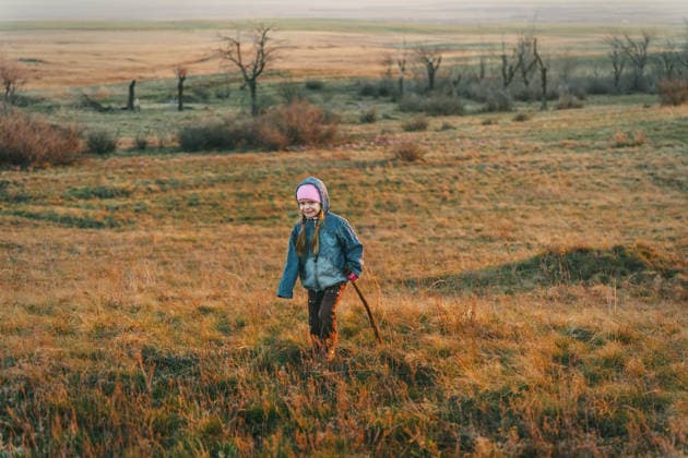 Happy child walking in dry grass field at sunset. Adventure. Orenburg, Orenburg Oblast, Russia CR_LQBD251229A-1920256-01 ,model released, Symbolfoto