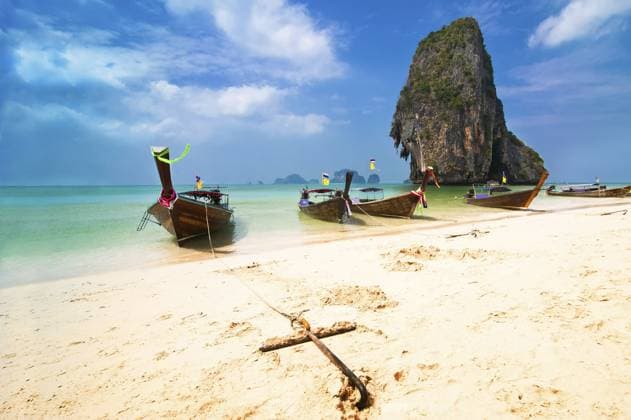 Tropische Strandlandschaft. Traditionelle thailändische Langheckboote am Golf des Ozeans unter blauem Himmel. Pranang Höhlenstrand, Railay, Krabi, Thailand Tropical beach landscape. Thai traditional long tail boats at ocean gulf under blue sky. Pranang cave beach, Railay, Krabi, Thailand Copyright: imageBROKER @xImxPerfectxLazybon ibxiqx16180793.jpg