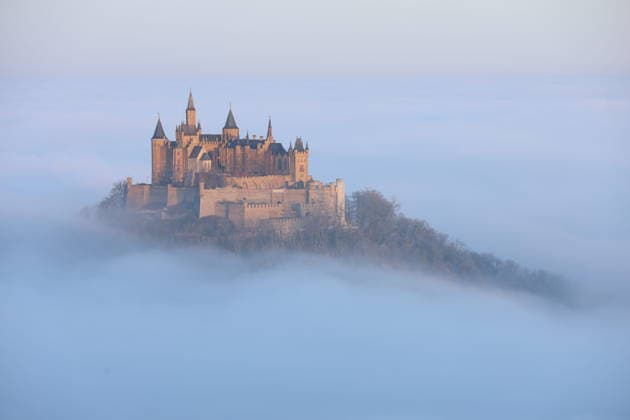 Burg Hohenzollern im Nebelmeer zum Sonnenaufgang, Die Burg Hohenzollern bei Hechingen (Zollernalbkreis), schwebt im Morgenlicht über einem Meer aus Nebel ein stiller Moment über den Wolken. Hechingen Baden-Württemberg Deutschland Hechingen