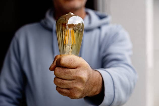 MR_ID32496_23615_SedatCakir.jpg A close up of a man in a blue hoodie holding a vintage Edison style bulb in his hand, symbolizing creativity and innovation. The focus is on the bulb against a soft background. Model Released Selena3726_ID32496_1107194_005 Copyright: xSelena3726x