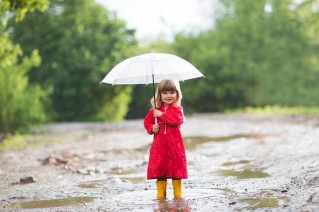 Glückliches Kind mit rotem Regenmantel, gelben Gummistiefeln und Regenschirm, das im Sommer draußen im Regen spielt. Happy child wearing a red raincoat and yellow wellies with an umbrella playing out in the rain in the summer outdoors (License=RF) ,model released, Symbolfoto Copyright: xZoonar.com UliaxZotaninax 24495997 ,model released, Symbolfoto ,property released