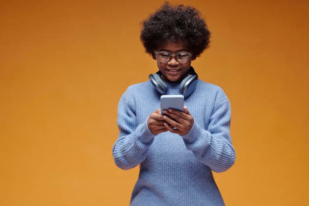 Teenage digital native with headphones using smartphone indoors model released, Symbolfoto, DSHF02513