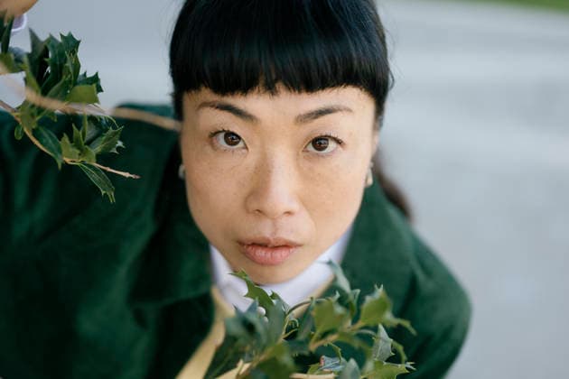 Authentic portrait of a woman outdoors looking at camera with green jacket model released, Symbolfoto, FLMZF02144