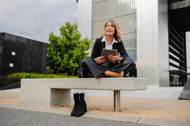 Businesswoman relaxing barefoot on bench with tablet in city model released, Symbolfoto, JCCMF13954