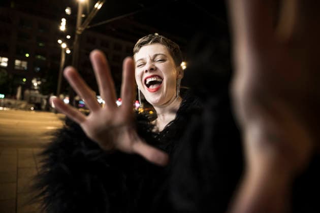 Expressive woman laughing and gesturing in city at night model released, Symbolfoto, UUF34917