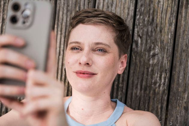 Happy woman smiling taking selfie on terrace outdoors model released, Symbolfoto property released, UUF34999