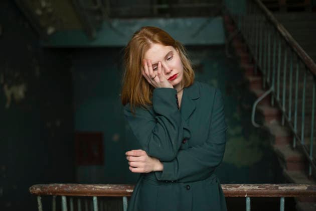 Red haired teenage girl in green jacket standing thoughtfully in old stairwell model released, Symbolfoto property released, VCF01150