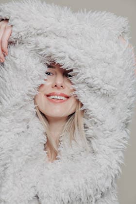 Blonde woman smiling in monochrome fur coat portrait model released, Symbolfoto, VSNF04529