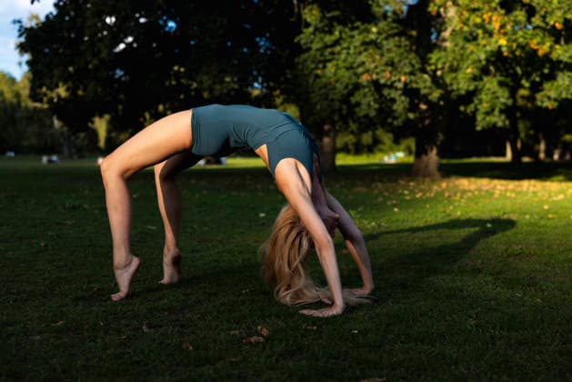 Woman doing yoga bridge pose in Berlin park at sunset outdoors model released, Symbolfoto, WPEF10153