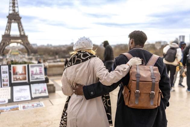 Vielfältiges Paar, das sich umarmt und den ikonischen Eiffelturm und das Stadtbild betrachtet, das Liebe, Reisen und romantische Entdeckungsreisen im Herzen von Paris symbolisiert Diverse couple embracing each other viewing the iconic eiffel tower and cityscape, symbolizing love, travel, and romantic exploration in the heart of paris Copyright: imageBROKER UnaixHuizi ibluhu16345599.jpg ,model released, Symbolfoto ,property released