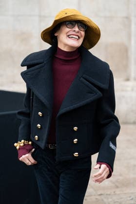 PFW - Patou Arrivals Inès de la Fressange wears red turtleneck sweater, black pants, black cropped coat, yellow bucket hat, outside Patou Menswear Fall Winter 2026-2027 show as part of Paris Fashion Week on January 25, 2026 in Paris, France. Photo by LounisPhotography ABACAPRESS.COM Paris France  Copyright: xLounisPhotography ABACAx