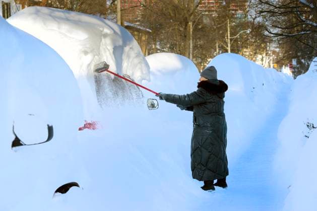 January 26, 2026, Toronto, On, Canada: A woman tries to sweep snow off her van after a massive snowstorm hit Toronto on Monday Jan. 26, 2026. Toronto Canada  - ZUMAc35_ 20260126_zaf_c35_080 Copyright: xFrankxGunnx