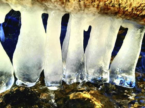 Klare Eiszapfen hängen über fließendem Wasser, eingefangen in einer winterlichen Landschaft Clear icicles hang over running water, caught in a wintry landscape Copyright: imageBROKER NilsxReisenberg ibxnsr16132459.jpg