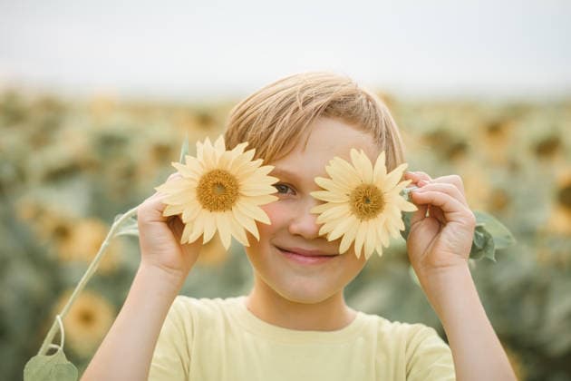 Lächelnder süßer Junge im Teenageralter, der auf einem Feld steht und Sonnenblumen hält. Sommerferien. Glückliche Kindheit. Smiling cute kid boy teen standing on a field and holding sunflowers. Summer holiday. Happy childhood (License=RF) ,model released, Symbolfoto Copyright: xZoonar.com ZulfiiaxIshmukhametovax 24517054 ,model released, Symbolfoto ,property released