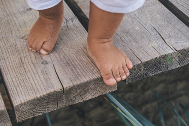 Kinderfüße im Sand auf einem Holzboden Children s feet in the sand on a wooden floor. Tanned legs of a one-year-old baby on a walk. (License=RF) ,model released, Symbolfoto Copyright: xZoonar.com EvgeniiaxParkhomenkox 24529720 ,model released, Symbolfoto ,property released