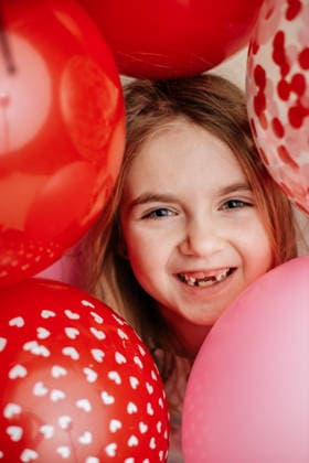 Smiling girl surrounded by red and pink Valentine s balloons Concordia, Kansas, United States CR_ZMDZ260126B-1950256-01 ,model released, Symbolfoto