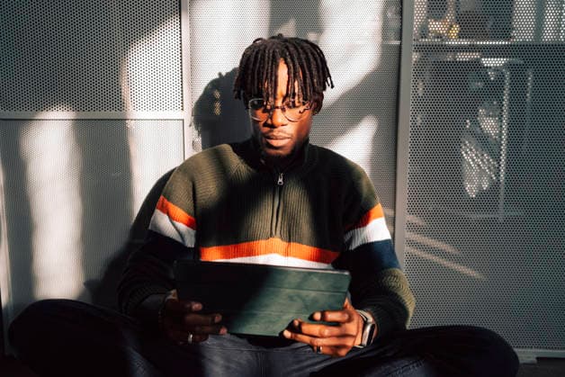 Male business professional with braided hair using tablet PC while sitting in office Sweden, Stockholm, model released, property released Copyright: xMaskotx , MA123136 MA123136