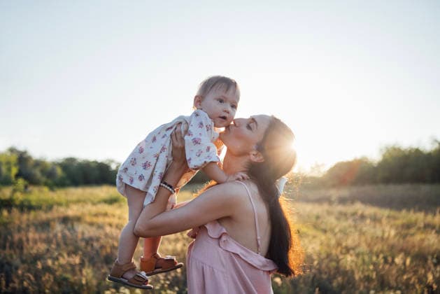 Mutter, die ihr Kind in einem sonnenbeschienenen Feld hält, einen freudigen Moment teilt, umgeben von der Schönheit der Natur, die Essenz der Liebe und der familiären Verbundenheit in einer ruhigen Umgebung einfängt. Woman embraces her toddler in a sunlit field, enjoying a tender moment together, surrounded by lush greenery and the warmth of the sun, symbolizing love and joy (License=RF) ,model released, Symbolfoto Copyright: xZoonar.com DashaxPetrenkox 24543510 ,model released, Symbolfoto ,property released