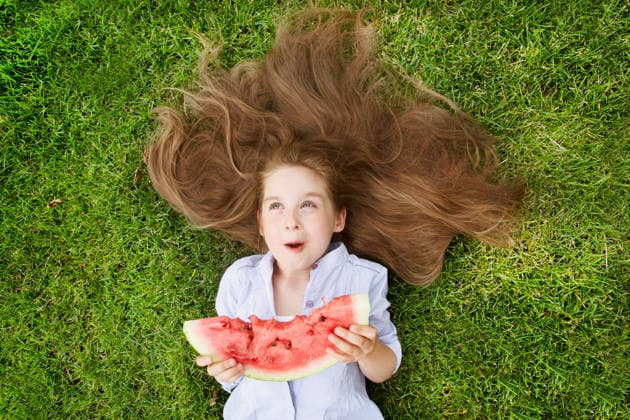 Fröhliches kleines Mädchen, das im Sommer auf dem Rasen Wassermelone isst Happy little girl eating watermelon on the grass in summertime (License=RF) ,model released, Symbolfoto Copyright: xZoonar.com UliaxZotaninax 24540084 ,model released, Symbolfoto ,property released