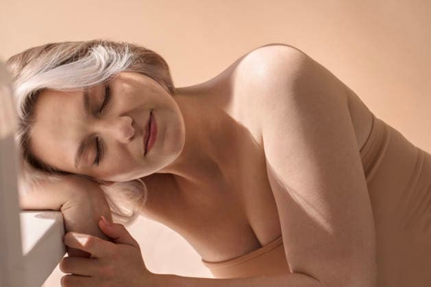 Weibliches Model mit hellem Haar, den Kopf auf den Arm gestützt, mit ruhigem Gesichtsausdruck und sanfter Beleuchtung, wodurch eine friedliche und intime Atmosphäre in einer minimalistischen Umgebung entsteht. Woman with light hair is resting her head on her arm, exuding calmness and tranquility in a softly lit, minimalistic environment that enhances her beauty (License=RF) ,model released, Symbolfoto Copyright: xZoonar.com DashaxPetrenkox 24547039 ,model released, Symbolfoto ,property released