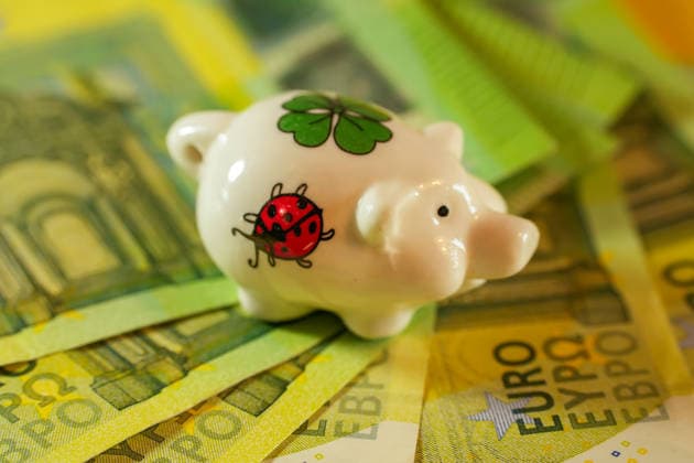 Miniatur-Sparschwein auf 100-Euro-Banknoten. In der Geschäftswelt als Symbol für Glück und Wohlstand.