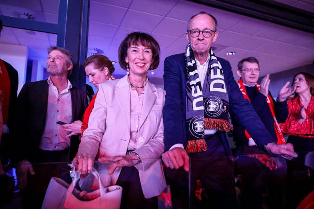 01.02.2026, Handball, Men s EHF EURO 2026, Deutschland - Dänemark, Jyske Bank Boxen in Herning, Final: Der deutsche Bundeskanzler Friedrich Merz (Kanzler Politik Politiker CDU) verfolgt das Spiel mit Fanschal um den Hals zusammen mit Ehefrau Charlotte Merz (links). Dänemark