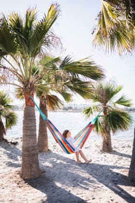 Pull back of a girl sitting on a hammock at a beach. United States, California, San Diego CR_CHDO260201-1945172-01 ,model released, Symbolfoto