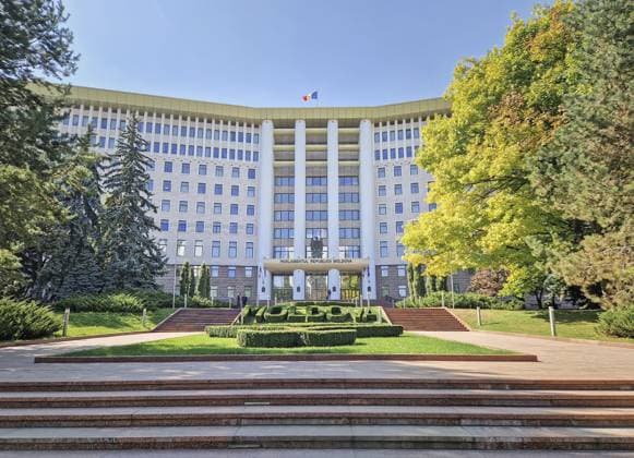 Chisinau, Moldawien — 24. September 2025 Parlamentsgebäude der Republik Moldawien mit der moldauischen Flagge auf dem Dach und einem großen Topiary Garten mit Blumen davor Chisinau, Moldova - September 24, 2025 Republic of Moldova parliament building with the Moldovan flag waving on the roof, and a large topiary garden with flowers in front Copyright: imageBROKER PsychoShadow ibxaiu16355563.jpg