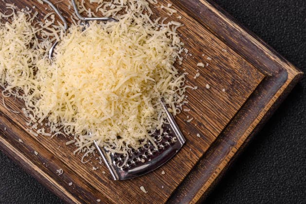 Geriebener Parmesankäse als Zutat zum Kochen oder Backen. Geriebener Parmesankäse Grated Parmesan cheese as a cooking or baking ingredient. Grated Parmesan cheese as a food background for your design (License=RF) Copyright: xZoonar.com TetianaxChernykovax 24585431