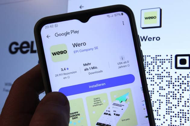 Auf einem Smartphone wurde die App vom Zahlungsdienst Wero bei Google Play aufgerufen worden. Dahinter wurde auf einem Laptop die Website von Wero aufgerufen. Symbolbild Symbolfoto. Schnelsen Hamburg *** The app from the Wero payment service was accessed on Google Play on a smartphone The Wero website was then accessed on a laptop Symbol image Symbol photo Schnelsen Hamburg