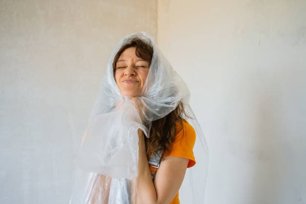 Malerin, die eine Plastiktüte über dem Kopf trägt und mit geschlossenen Augen Grimassen schneidet, während sie ihr Haus renoviert und die Tüte während der Malerarbeiten fest umklammert Female painter suffocating with plastic bag on her head while renovating a house, making a funny face with closed eyes, holding the plastic bag with her hands (License=RF) ,model released, Symbolfoto Copyright: xZoonar.com ElenaxShishkinax 23883986 ,model released, Symbolfoto ,property released