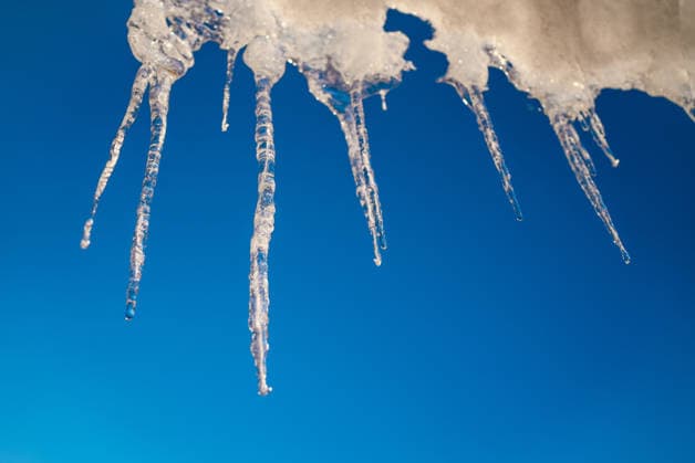 Scharfe Eiszapfen, die im warmen Sonnenlicht schmelzen, bilden eine malerische Winterszene vor einem strahlend blauen Himmel, die die Schönheit und Zerbrechlichkeit der jahreszeitlichen Veränderungen in der Natur zeigt Sharp icicles melting under warm sunlight create a picturesque winter scene against a vibrant blue sky, showcasing the beauty and fragility of nature s seasonal changes (License=RF) Copyright: xZoonar.com ElenaxShishkinax 23946303