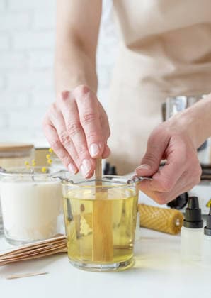 Nahaufnahme einer Frau, die den Holzdocht in eine handgemachte Kerze steckt Nahaufnahme einer Frau, die den Holzdocht in eine handgemachte Kerze steckt (License=RF) Copyright: xZoonar.com ILONAxSHOROKHOVAx 24604178