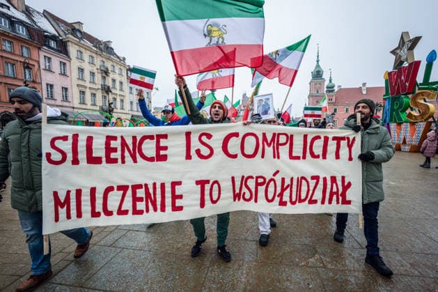 February 7, 2026, Warsaw, Mazovia, Poland: The march begins behind a banner that says, in English and Polish, Silence is complicity during the demonstration. Protesters of the Iranian diaspora gather in Warsaw, Poland to march from Castle Square to Staszic Palace. Following last month s anti-government protests in Iran, the demonstrators rally demanding an end to the violence of the Islamic Republic, and regime change to return the monarchy, which would install the Crown Prince of Iran, Reza Pahlavi, the son of the deposed Shah. The rally includes singing, chanting, dancing, and the waving of flags. Warsaw Poland - ZUMAs197 20260207_aaa_s197_302 Copyright: xNeilxMiltonx