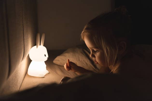 girl on a bed, playing with glowing rabbit-shaped lamp Antalya, Antalya, Türkiye CR_BMEE260206-1961327-01 ,model released, Symbolfoto