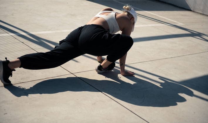 woman stretching legs on basketball court on sunny day San Miguel de Allende, Guanajuato, Mexico R_WDJM260207-1961914-01 ,model released, Symbolfoto
