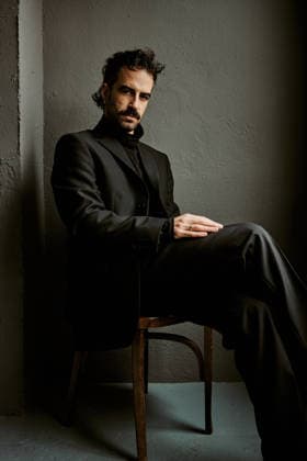 Pensive man in black suit sitting alone in dramatic shadows Jaén, Andalusia, Spain CR_NNSU260210A-1962291-01 ,model released, Symbolfoto