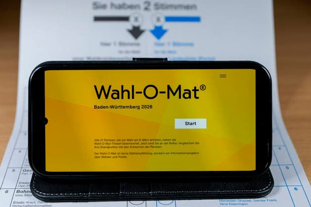 Ein Smartphone zeigt den Startbildschirm der App Wahl-O-Mat, mit der Wählerinnen und Wähler anhand von Thesen die 21 zugelassenen Parteien zur Entscheidungsfindung miteinander vergleichen können, Wahlhilfe aber keine Wahlempfehlung, das Handy liegt auf dem amtlichen Stimmzettel zur Landtagswahl in Baden-Württemberg (BW) am 8. März 2026, Wahlkreis 34 Heidelberg, Symbolfoto, Symbolbild, Symbol, 11.02.2026, Heidelberg (Deutschland), Politik, Feature, Landtagswahl Baden-Württemberg 2026 *** A smartphone shows the start screen of the Wahl O Mat app, which voters can use to compare the 21 registered parties with each other using theses to make a decision, voting aid but no voting recommendation, the cell phone is on the official ballot paper for xozx