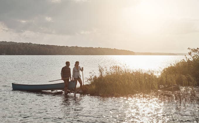 Couple, date and travel with canoe, lake and people on adventure, bonding and love on summer holiday. Outdoor, man and woman with boat on water, romance or together in nature, sunshine and space. model released property released Copyright: xx