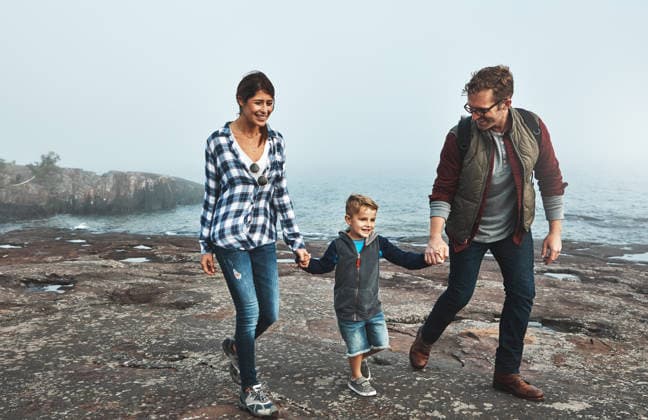 Happy, family and holding hands with child, hiking and people with son on holiday, space and travel. Outdoor, man and woman with boy on adventure, trekking or walking with kid in nature and bonding. model released property released Copyright: xx